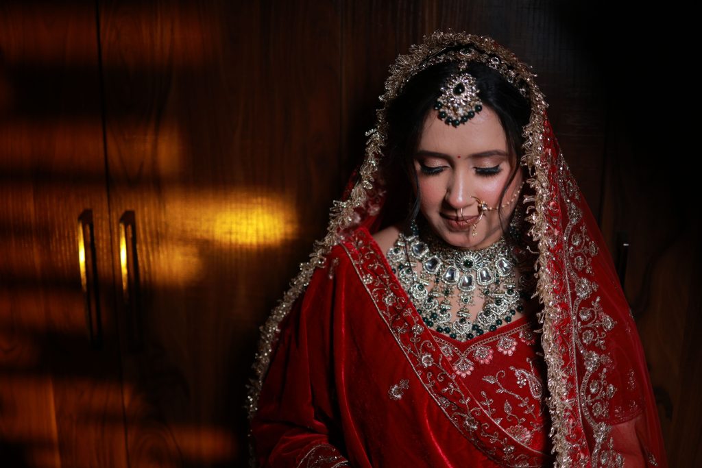 Beautiful Indian bride adorned in traditional attire with ornate jewelry and red saree.